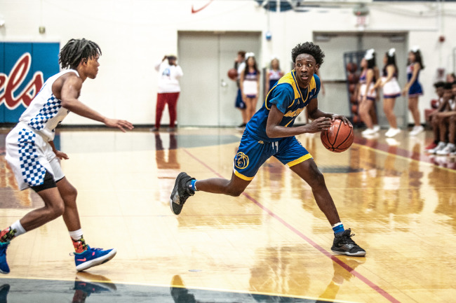 A high school basketballer crossing his opponent during a game