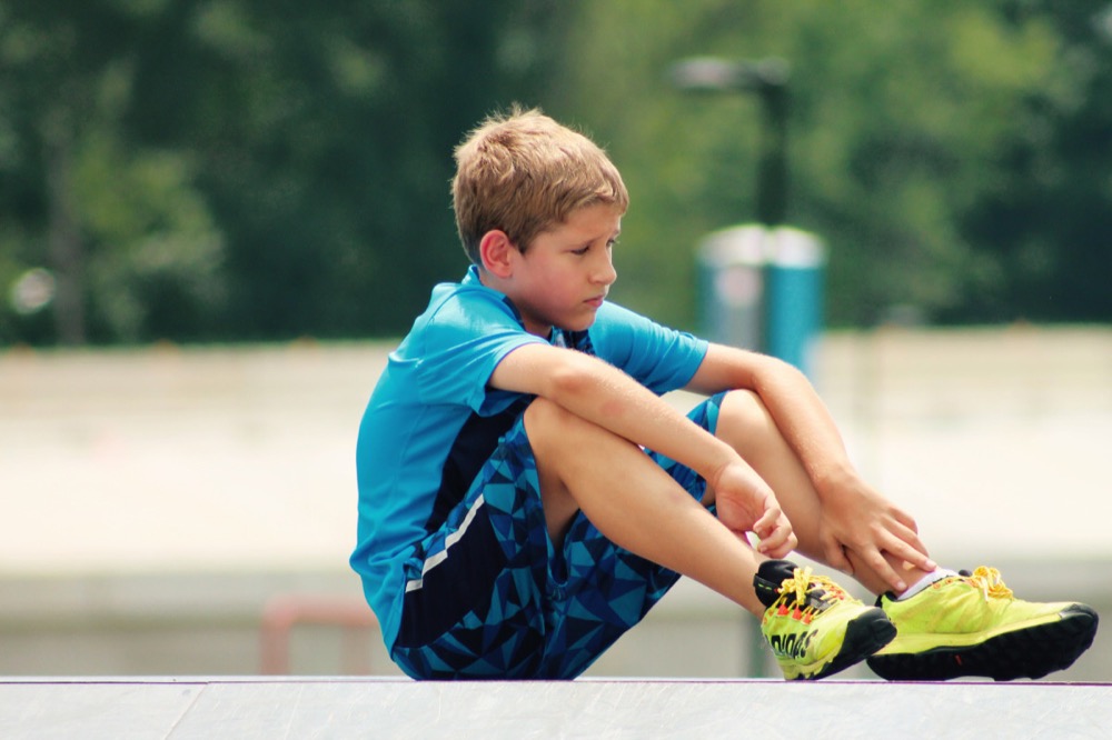 A young teenager sitting out sport.