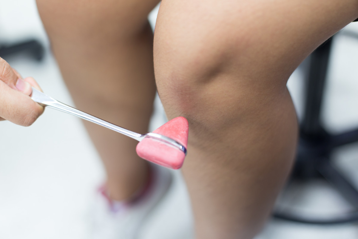 A close-up photograph of a doctor manipulating a patient's knee