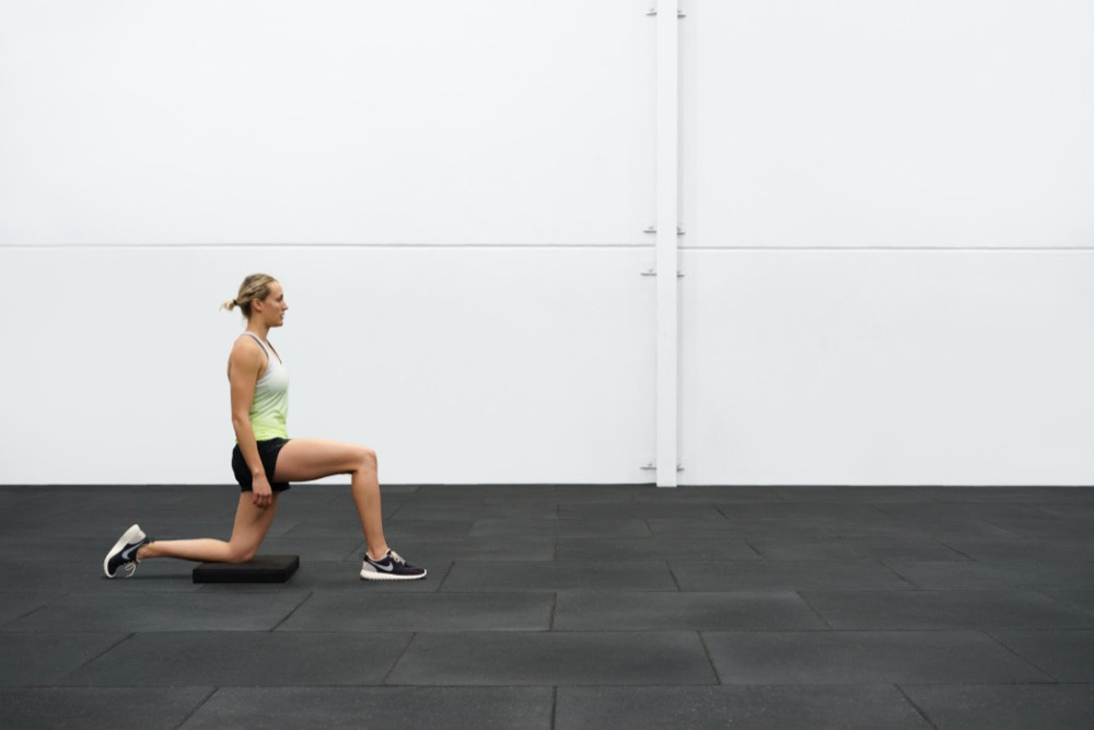 Demonstrating the kneeling hip flexor stretch