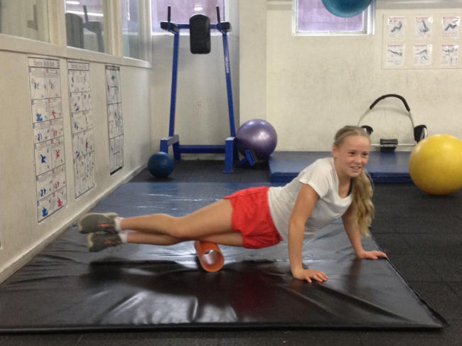 Sarah using PVC plumbing pipe as a roller for her quads