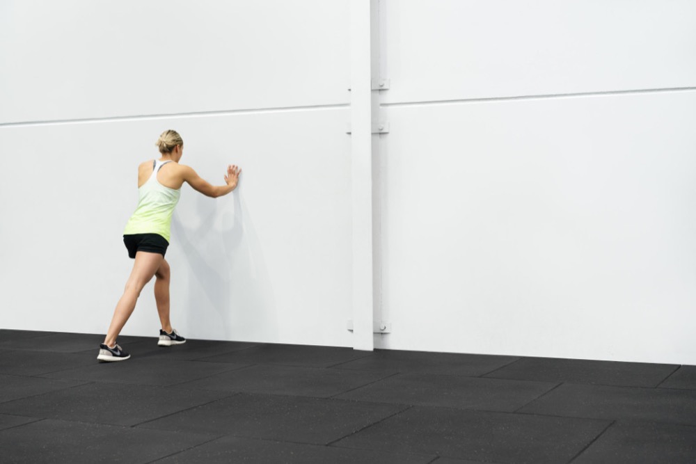 Demonstrating the standing calf stretch